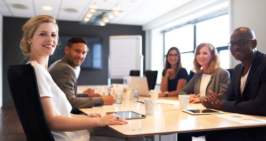 41683456 - group of young executives smiling at camera during a work meeting.